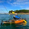 Paddling a fishing kayak whilst wearing the Palm Kola Angler PFD