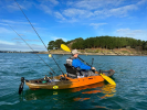 Paddling a fishing kayak whilst wearing the Palm Kola Angler PFD