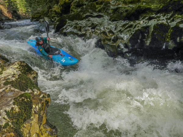 A paddler using the Pyranha Scorch kayak in river rapids
