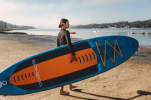 Carrying the Spinera Let's Paddle SUP down the beach to the water