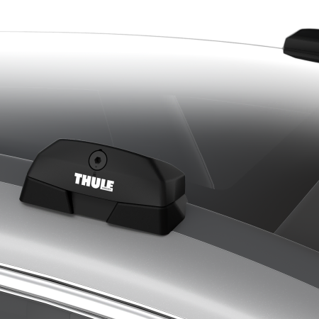 A Thule fitting kit cover attached to a fix-point foot pack on a car.